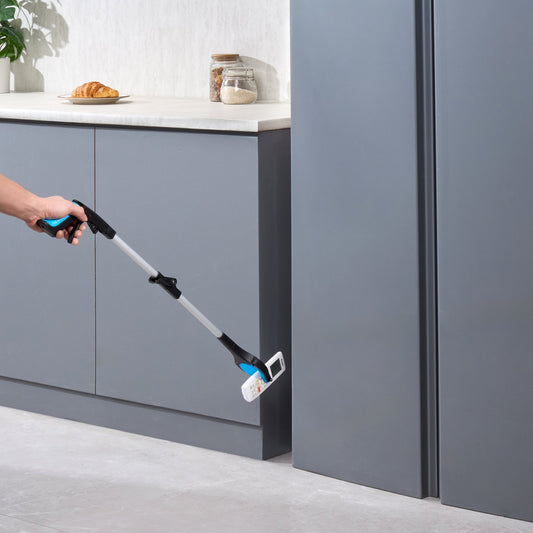 Foldable 32-inch reacher grabber picking up a small item from the kitchen floor.